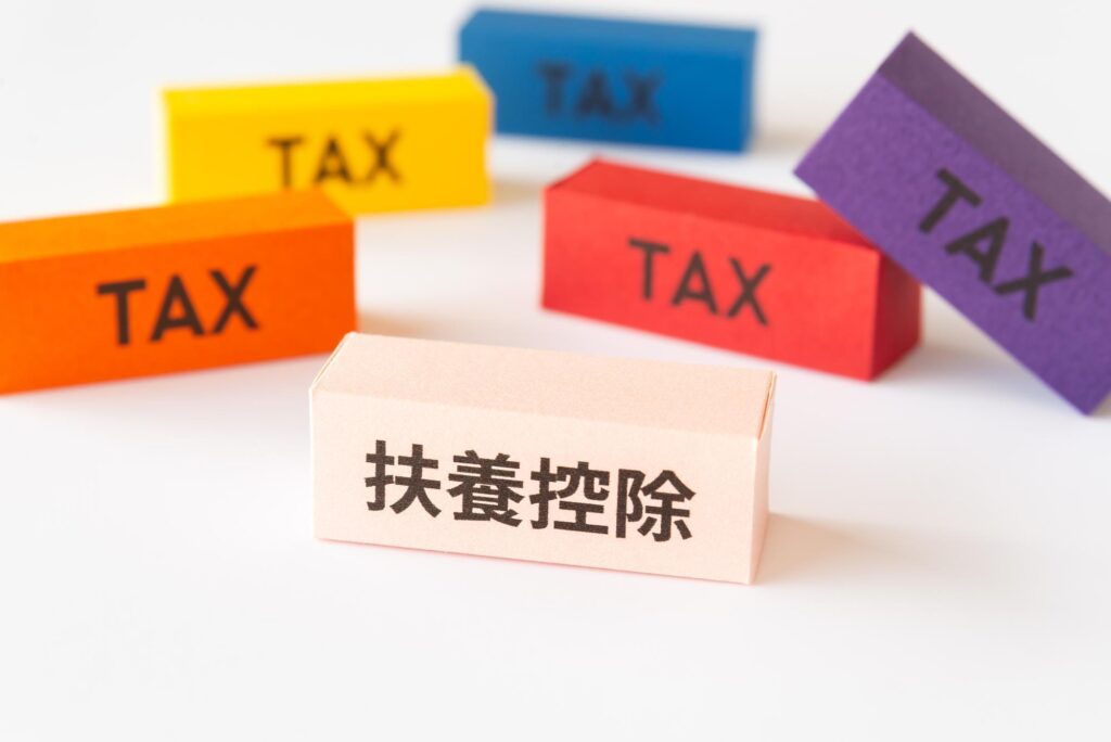 「扶養控除」と書かれたブロックと、周囲に「TAX」と書かれたカラフルなブロックが配置されている