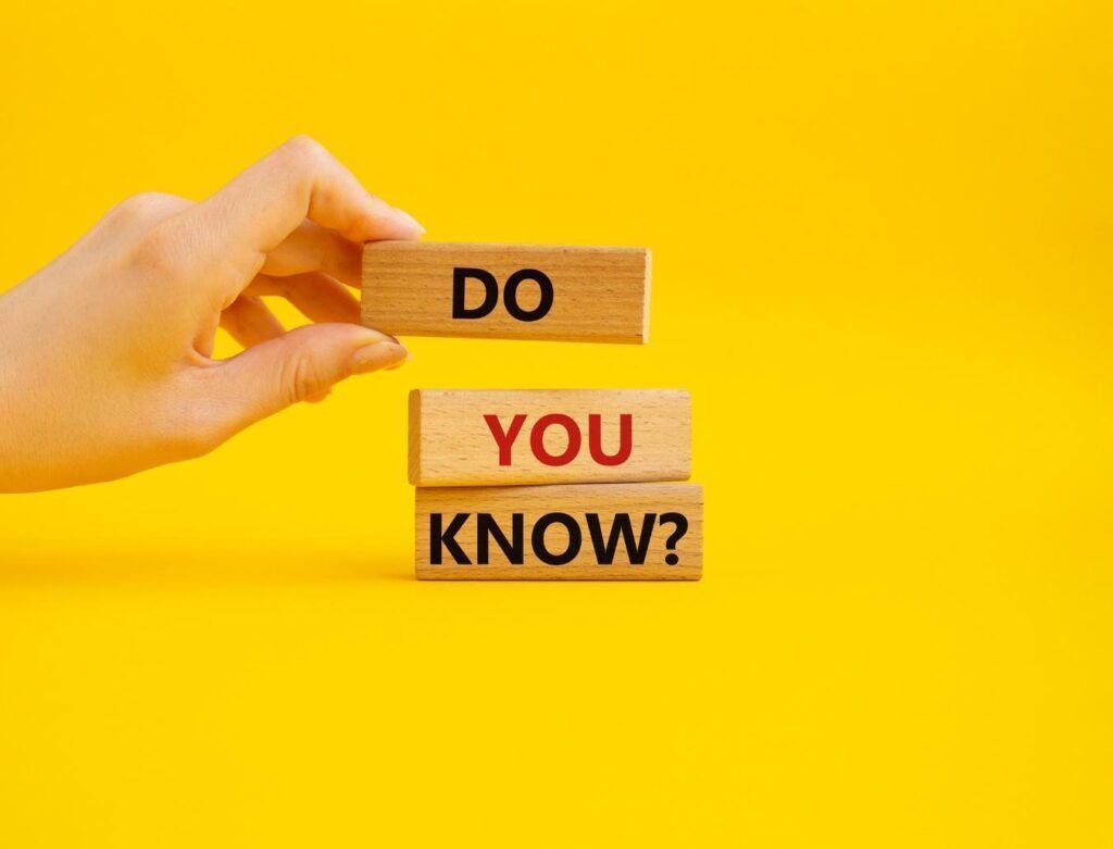 「DO」「YOU」「KNOW?」と書かれた3つの積み木を積む人の手