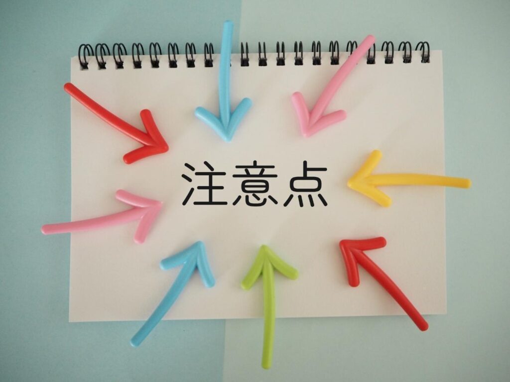 スケッチブックに書かれた「注意点」の文字に集まるように置かれたカラフルな矢印